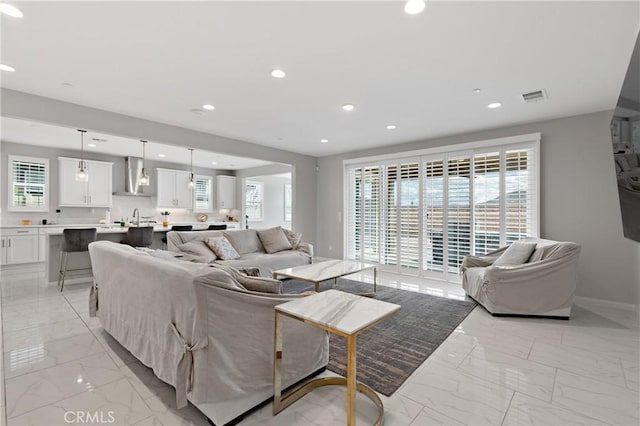 living area featuring marble finish floor, visible vents, and recessed lighting