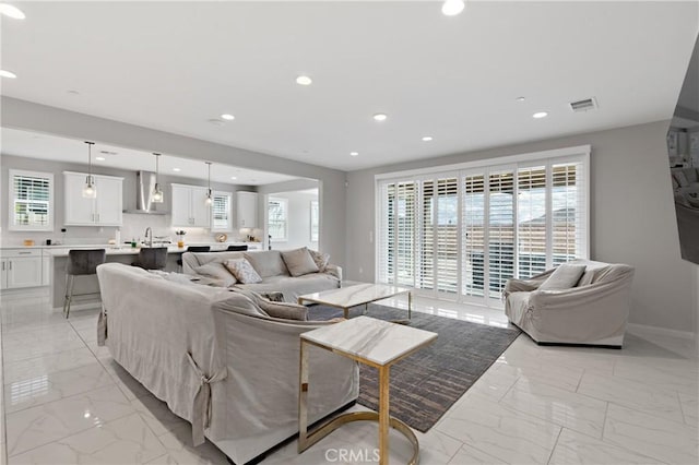 29945 Urtica Ct, Menifee, CA 92584 - living room with recessed lighting, visible vents, marble finish floor, and baseboards