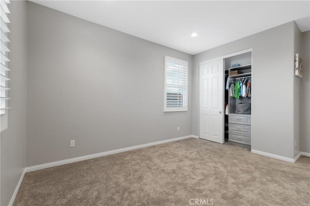 unfurnished bedroom featuring light carpet, baseboards, a closet, and recessed lighting