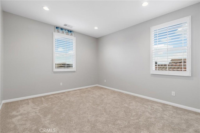 carpeted empty room featuring visible vents, baseboards, and recessed lighting