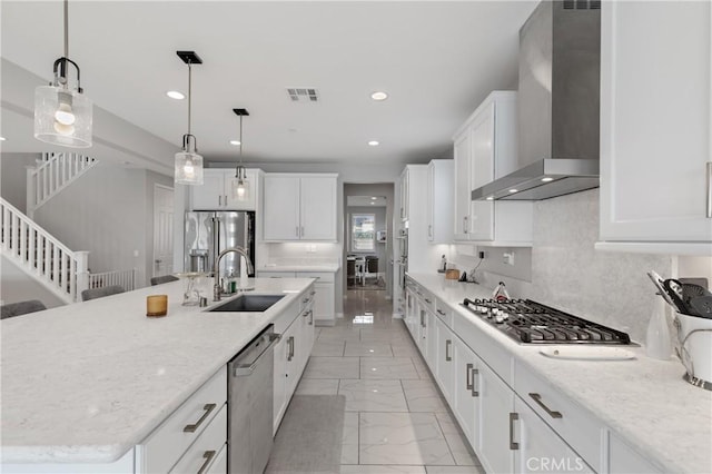 kitchen with a sink, visible vents, marble finish floor, wall chimney range hood, and appliances with stainless steel finishes