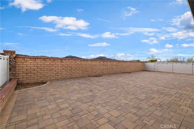 view of patio with a gate, fence, and a mountain view