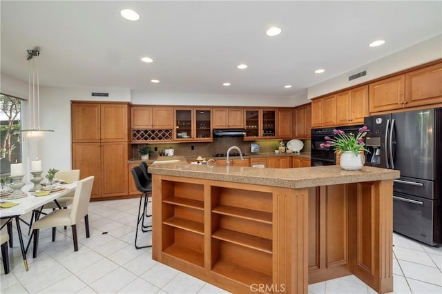 kitchen with black appliances, brown cabinetry, open shelves, and visible vents