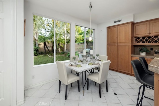 dining space featuring baseboards, visible vents, and light tile patterned flooring