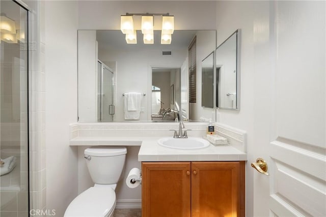 bathroom featuring visible vents, a stall shower, vanity, and toilet