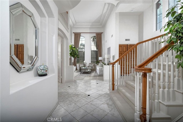 entryway featuring stairway, visible vents, and ornamental molding