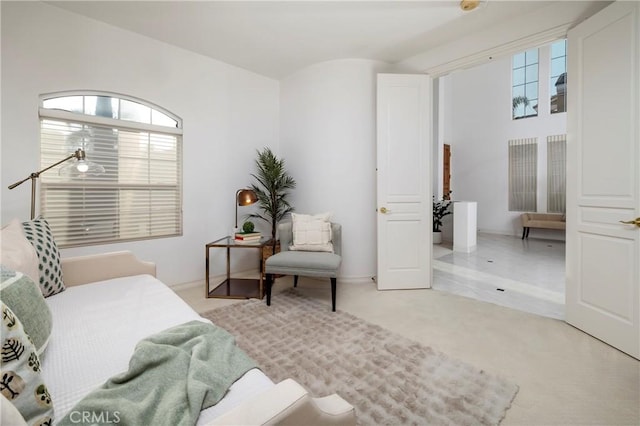 bedroom with multiple windows and light carpet