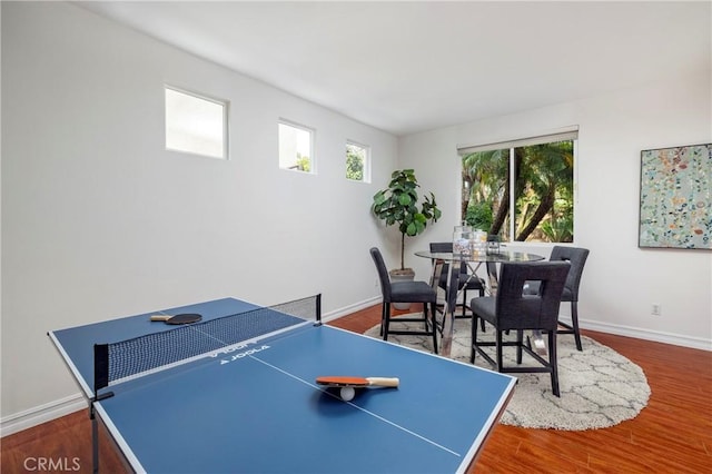 recreation room with baseboards and wood finished floors