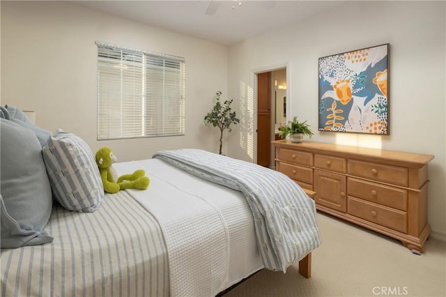 bedroom with a ceiling fan and light colored carpet