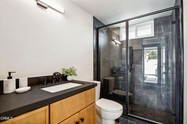 full bathroom featuring a stall shower, toilet, and vanity