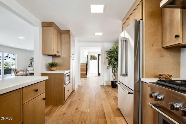 kitchen with light countertops, high end appliances, and under cabinet range hood