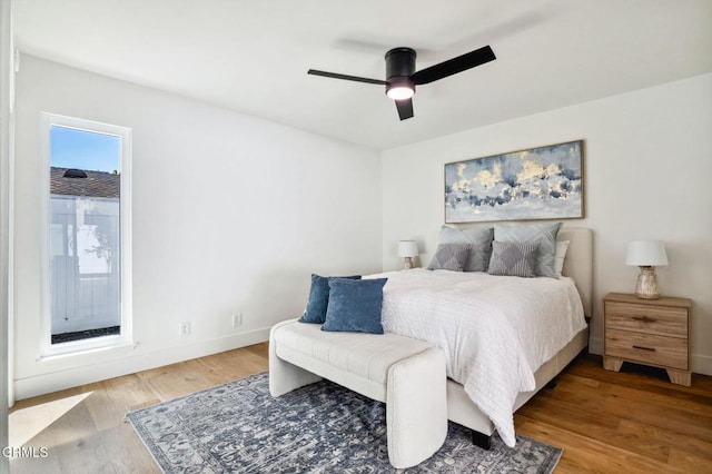 bedroom featuring wood finished floors, baseboards, and ceiling fan