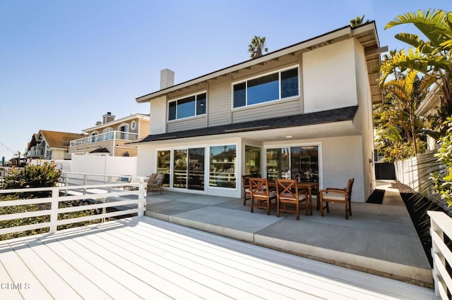 rear view of property with a deck, a fenced backyard, and stucco siding