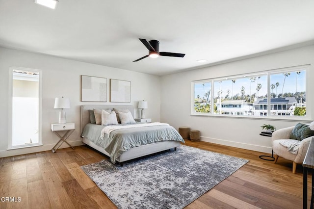 bedroom with a ceiling fan, baseboards, and wood finished floors