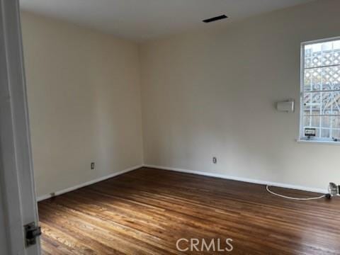 unfurnished room featuring wood finished floors and visible vents