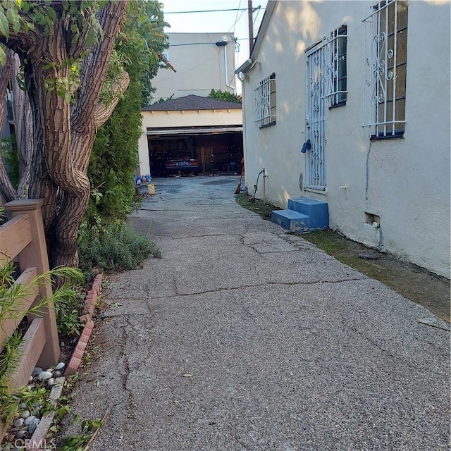 view of property exterior featuring stucco siding, entry steps, and a detached garage