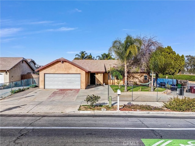 ranch-style home featuring a fenced front yard, concrete driveway, a garage, and stucco siding