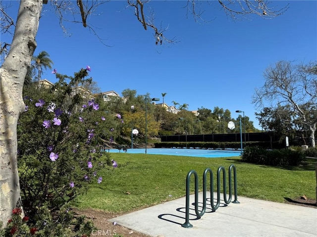 surrounding community featuring a lawn and community basketball court