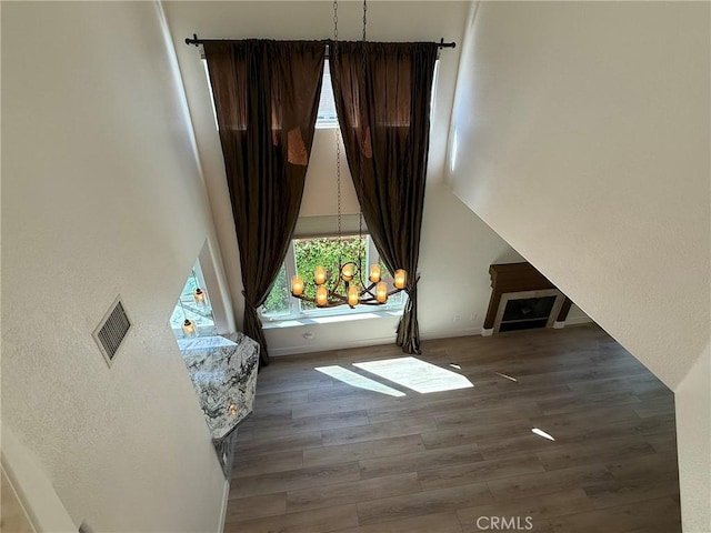 bedroom with visible vents, a towering ceiling, and wood finished floors