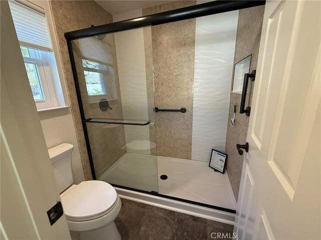 bathroom with toilet and a stall shower