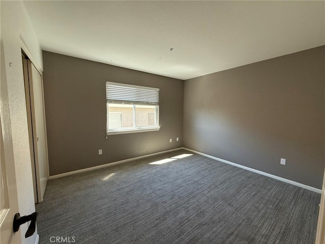 unfurnished bedroom with a closet, baseboards, and carpet floors