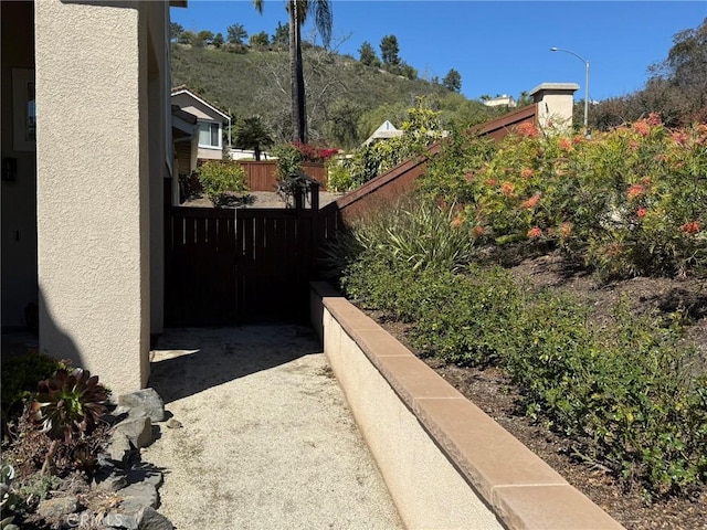 view of side of home with fence and stucco siding