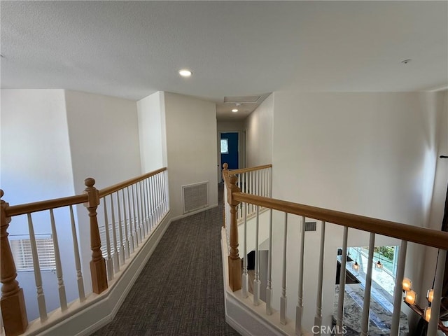 hall with recessed lighting, an upstairs landing, visible vents, and carpet floors