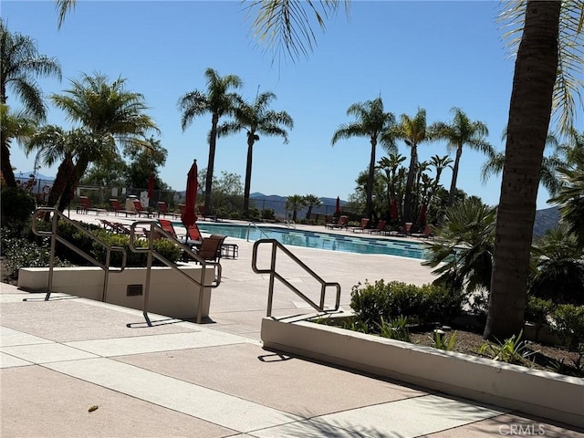 pool with a patio area and fence