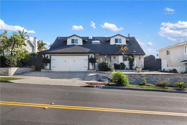 view of front of home featuring an attached garage, fence, and driveway