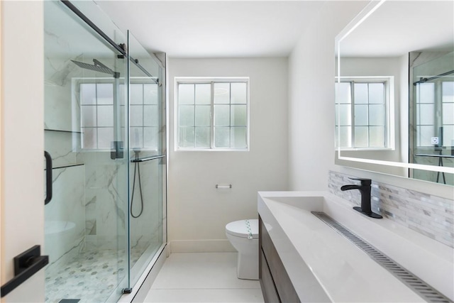 full bathroom with a marble finish shower, baseboards, toilet, and vanity