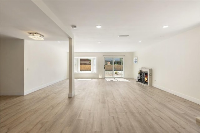 unfurnished living room featuring recessed lighting, light wood-style floors, visible vents, and a lit fireplace