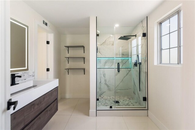 bathroom featuring a marble finish shower, visible vents, baseboards, tile patterned floors, and vanity