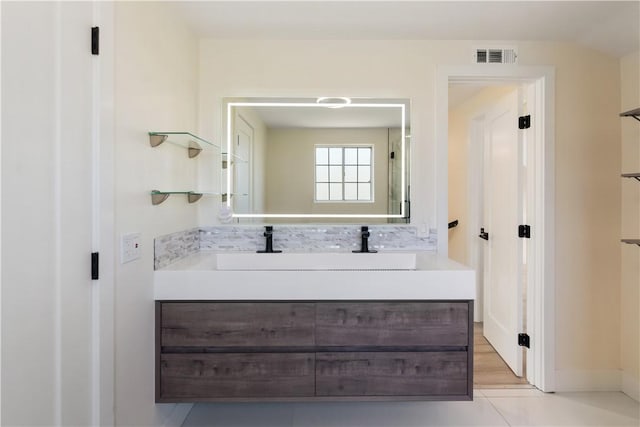 bathroom featuring visible vents, backsplash, and vanity