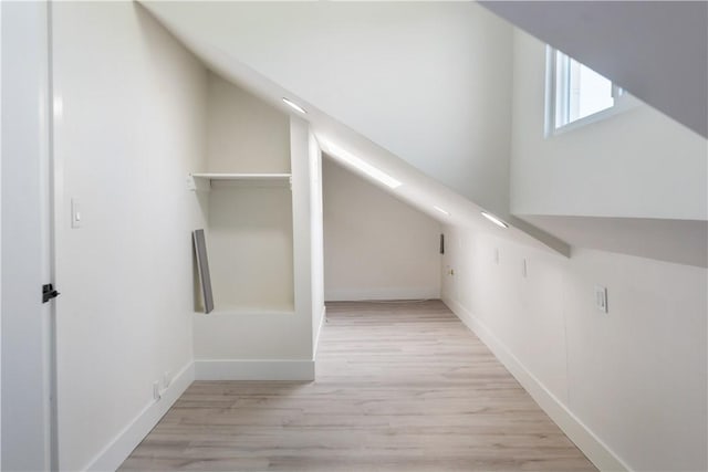 additional living space featuring light wood-style flooring and baseboards