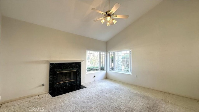 unfurnished living room featuring a high end fireplace, carpet flooring, high vaulted ceiling, and ceiling fan