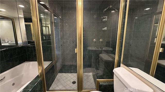 full bath with toilet, a stall shower, and tiled bath