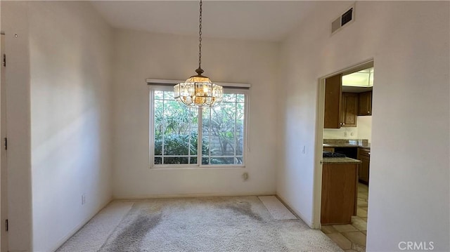 unfurnished dining area featuring a chandelier, visible vents, and light colored carpet