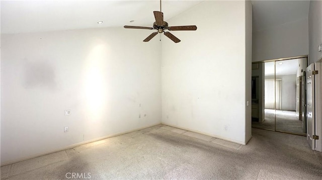 spare room featuring ceiling fan, carpet floors, and high vaulted ceiling