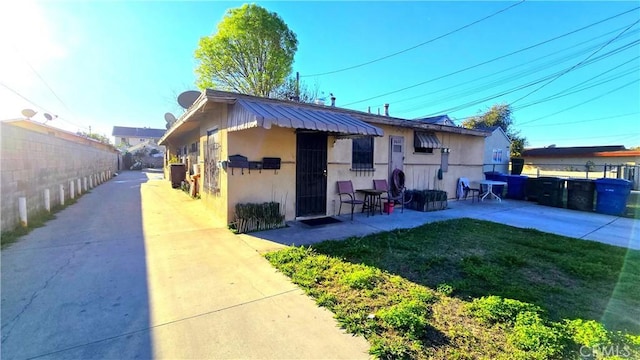 exterior space with a lawn, a patio area, fence, and stucco siding