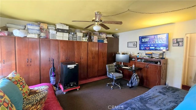 carpeted office space with a ceiling fan