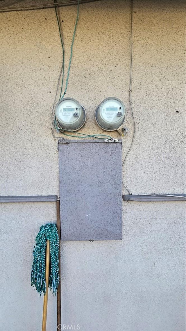 exterior details featuring electric meter and stucco siding