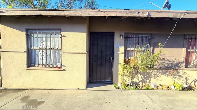 entrance to property featuring stucco siding