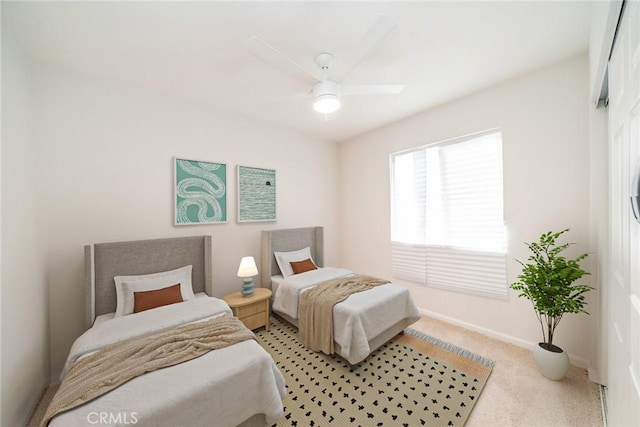 carpeted bedroom with a ceiling fan and baseboards