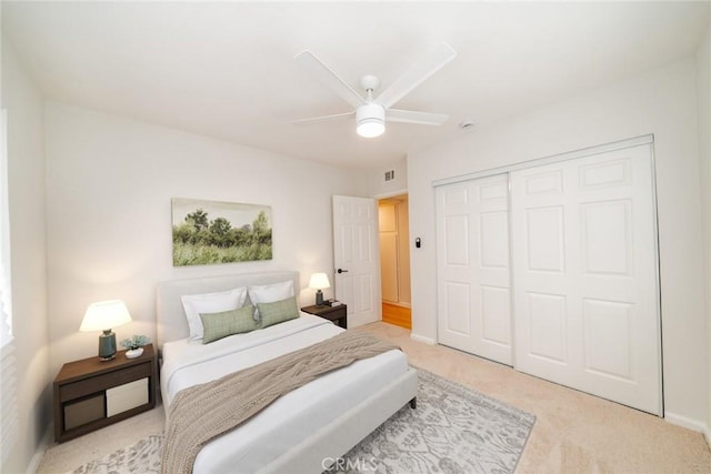 carpeted bedroom with ceiling fan, baseboards, and a closet