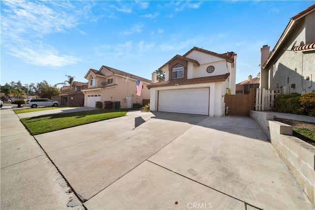 traditional-style house featuring stucco siding, driveway, fence, a garage, and a tiled roof