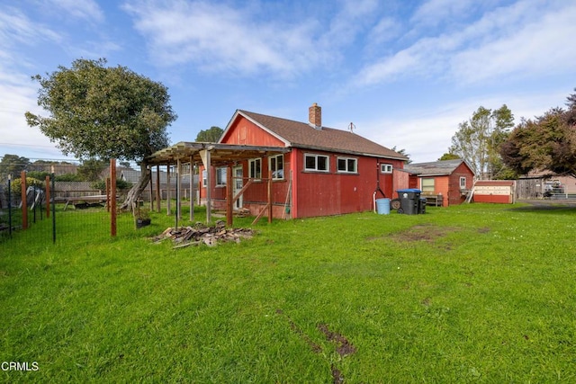 back of property featuring a yard, a chimney, and fence