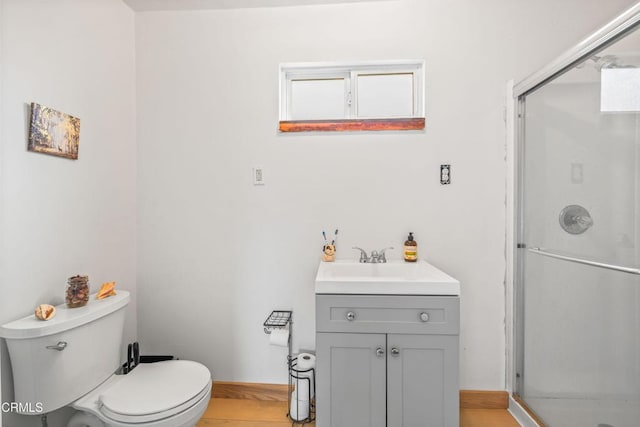 bathroom with a stall shower, vanity, and toilet