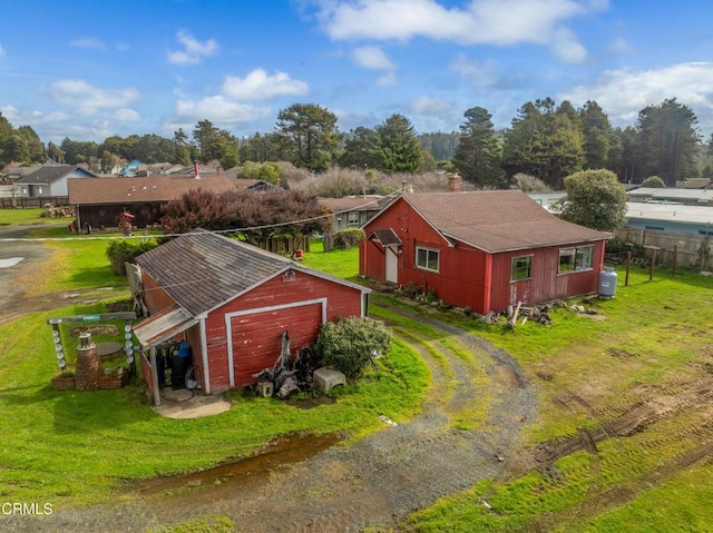 view of pole building with a yard, driveway, and fence