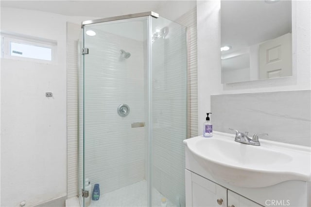 full bath with a shower stall and vanity