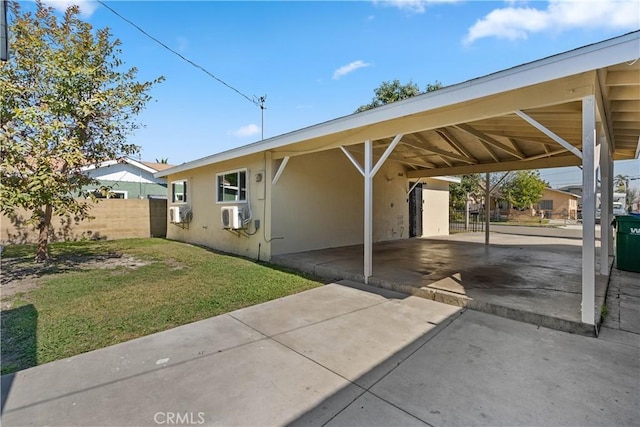 view of parking featuring an attached carport and fence